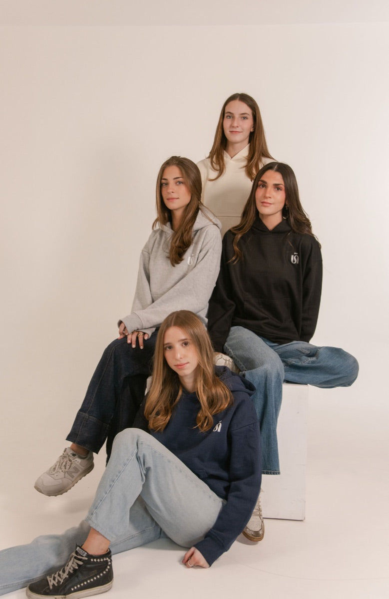 Grupo de amigas con hoodies Once Once en gris, negro y azul marino