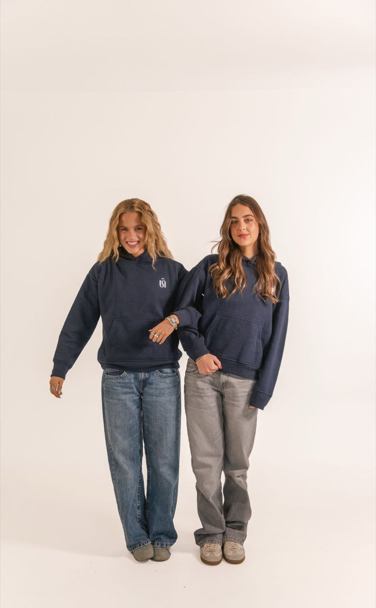 Dos amigas con hoodies azul marino y jeans